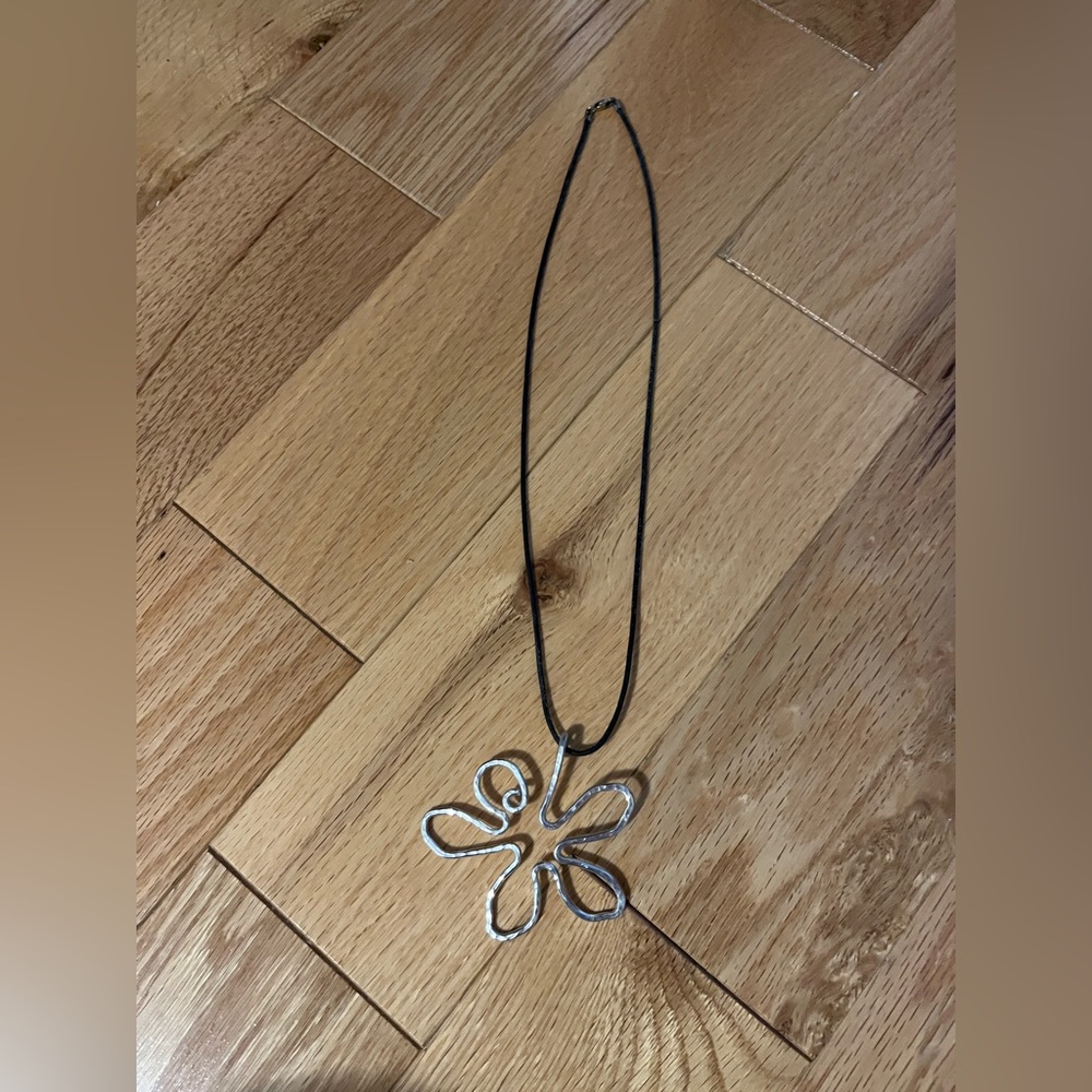 Silver tone daisy flower outline art necklace on black strand